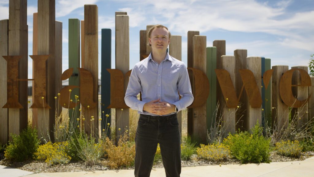 Development Manager, Mike Mortimer standing in front of Harlowe development logo.